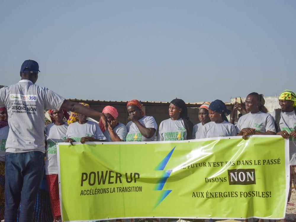 Participants du Power Up derrière une banderole contre les énergies fossiles